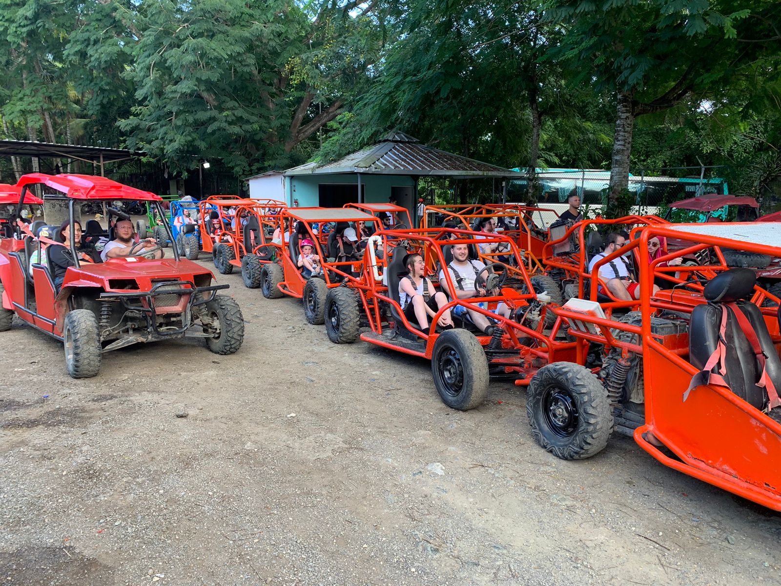 People riding buggies on a dirt road